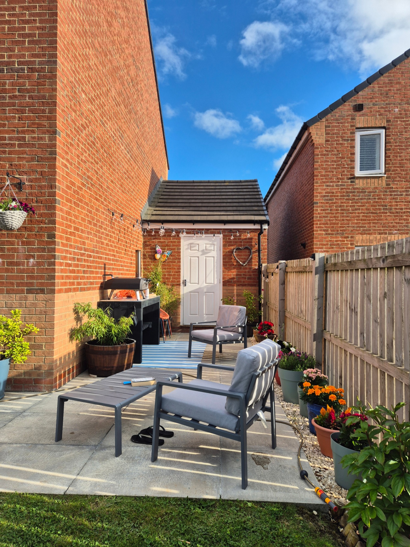 New build garden with fresh lawn, patio, fencing and borders, plus a custom timber pizza oven table