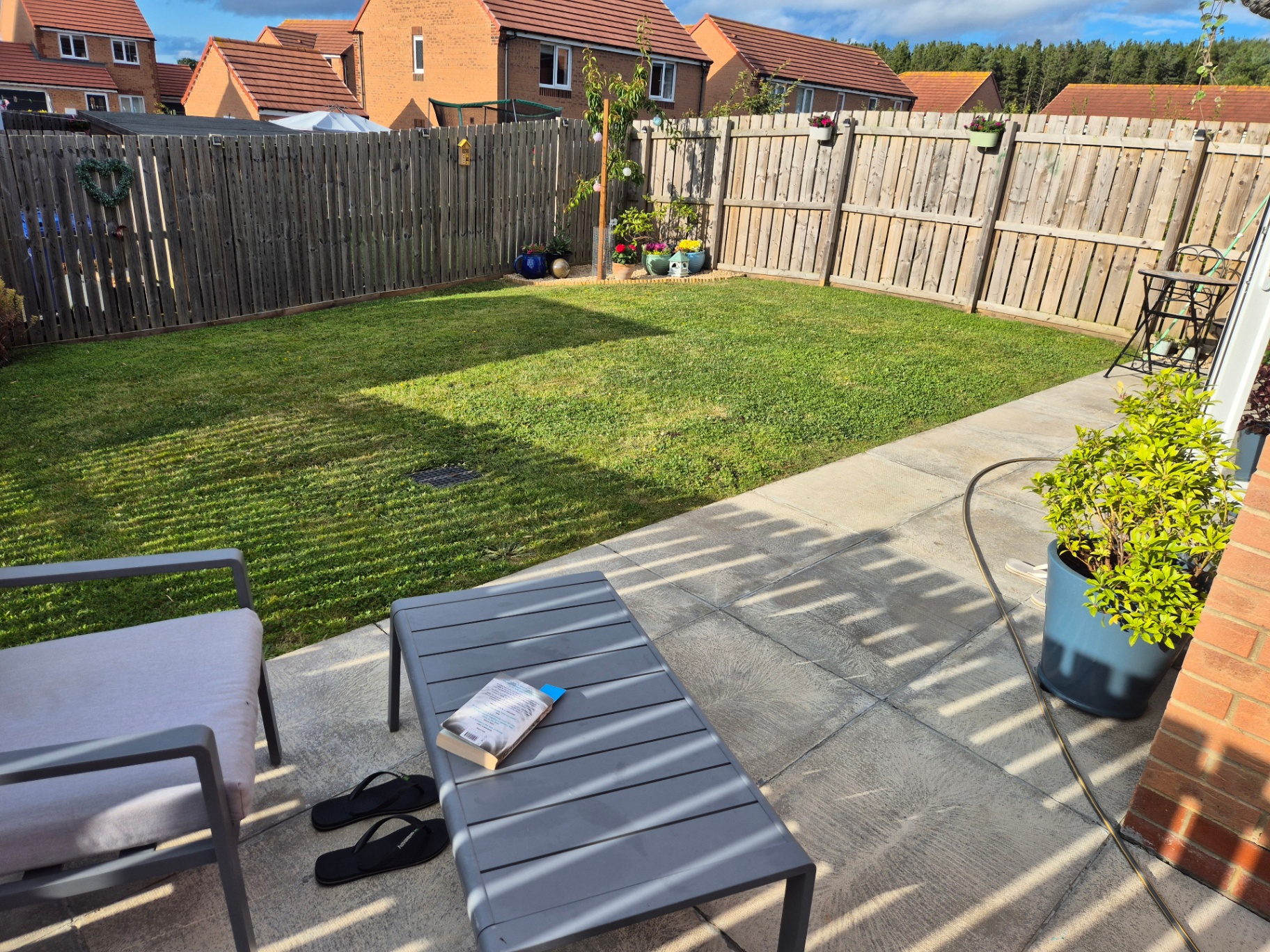 New build garden with fresh lawn, patio, fencing and borders, plus a custom timber pizza oven table